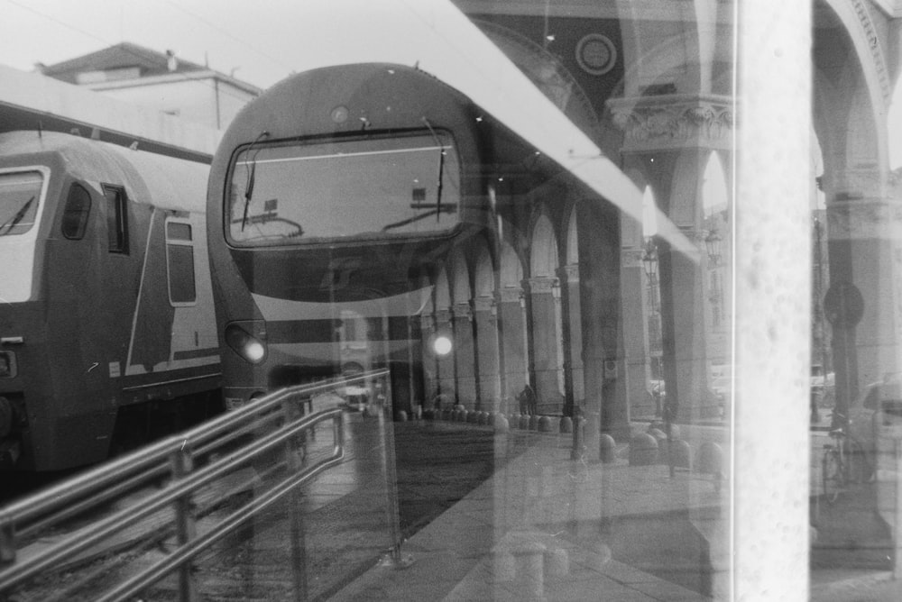 Ein Schwarz-Weiß-Foto von zwei Zügen an einem Bahnhof