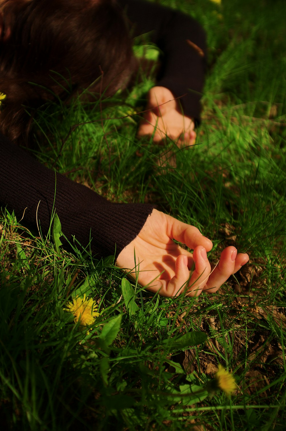 a person laying in the grass with their hands on the ground
