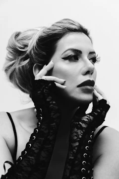 Black-and-white portrait of a model with avant-garde makeup and hair styling.