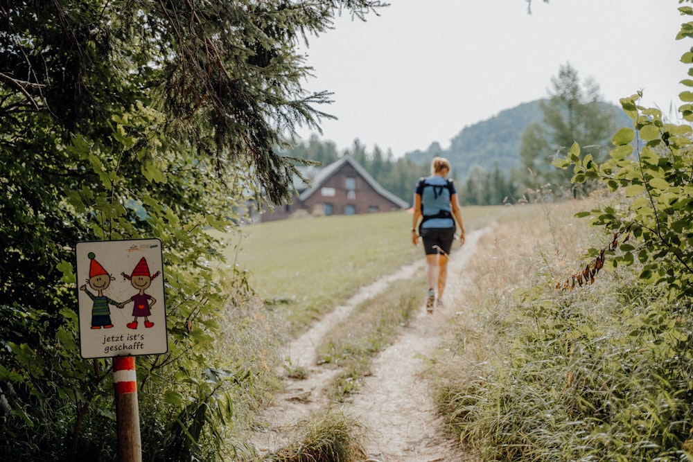 a person walking down a dirt path in a field