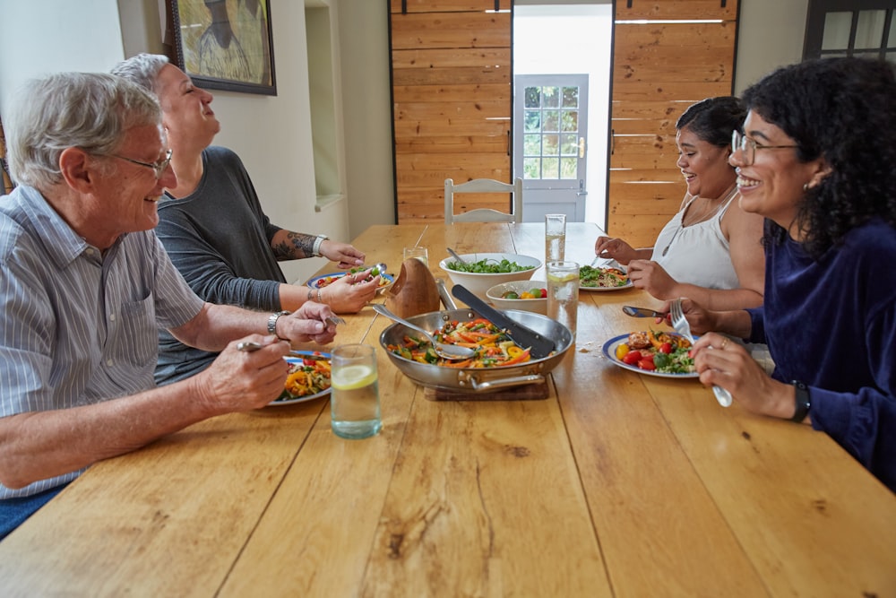 a group of people sitting around a table eating food