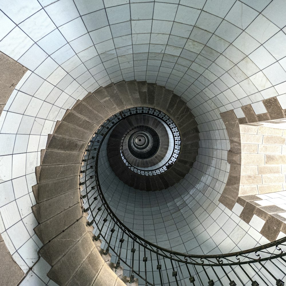 a spiral staircase in a building with tiled walls