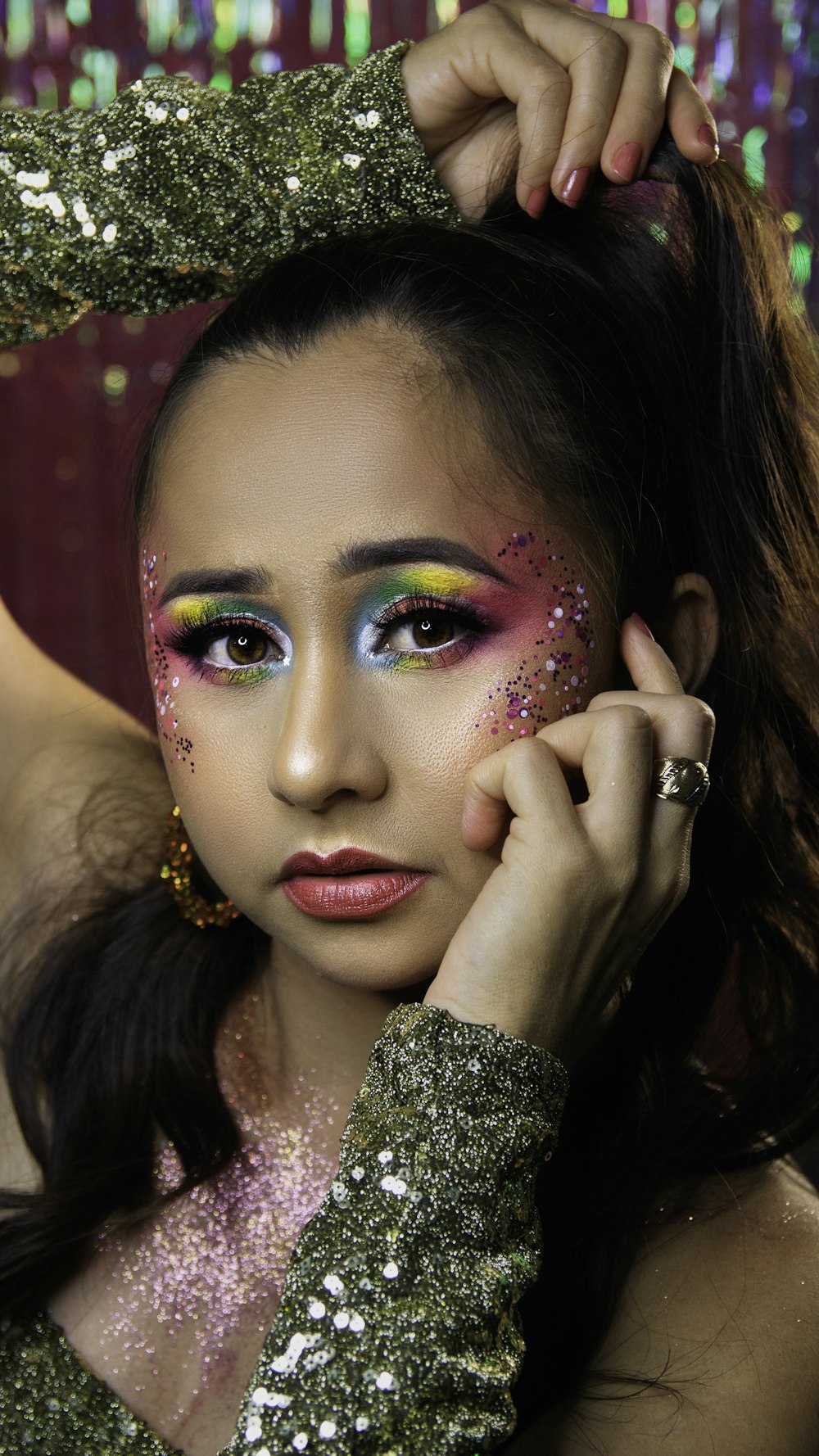a woman with glitter on her face posing for a picture