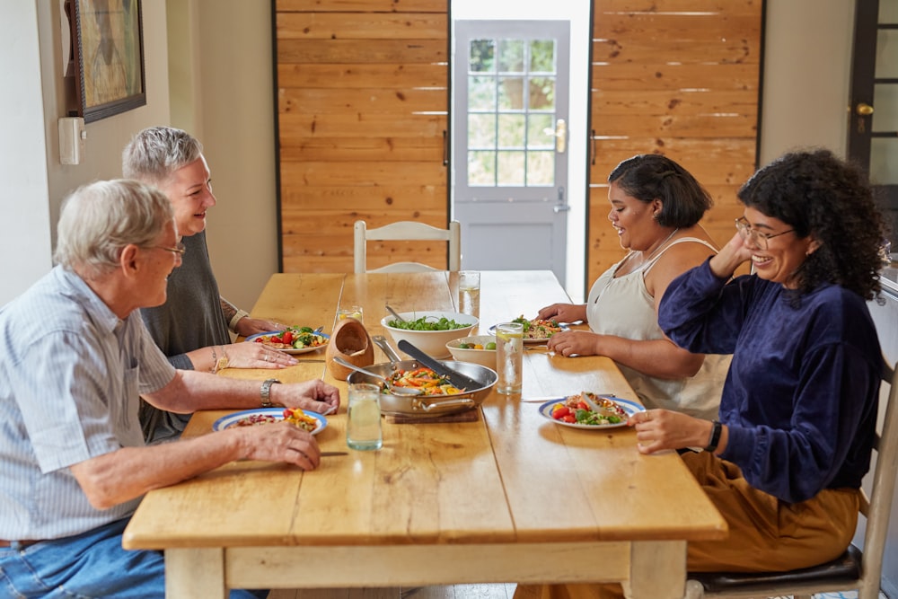 a group of people sitting around a wooden table