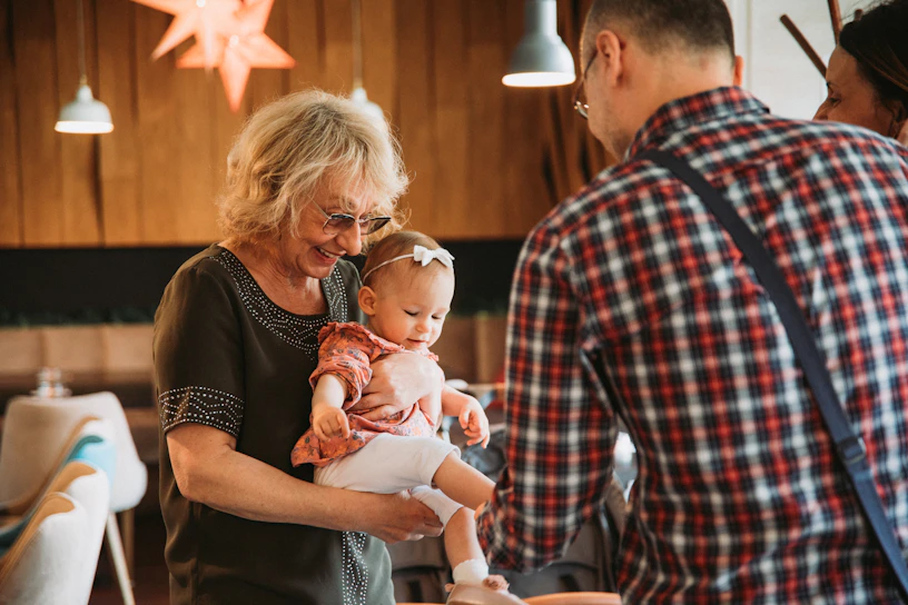 A young caregiver warmly assisting an elderly woman with daily tasks at home.