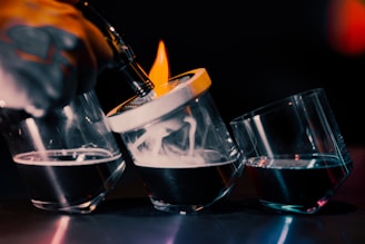A close-up of the saturix electric whiskey smoker glowing amber inside a smoky, dark bar setting with golden rings of smoke swirling around.