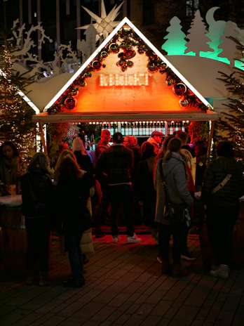 A cozy wooden stall at a German Christmas market, glowing with warm lights and festive decorations.