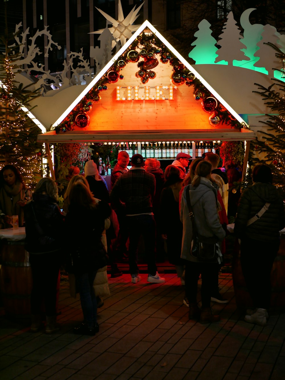 a group of people standing in front of a lit up house