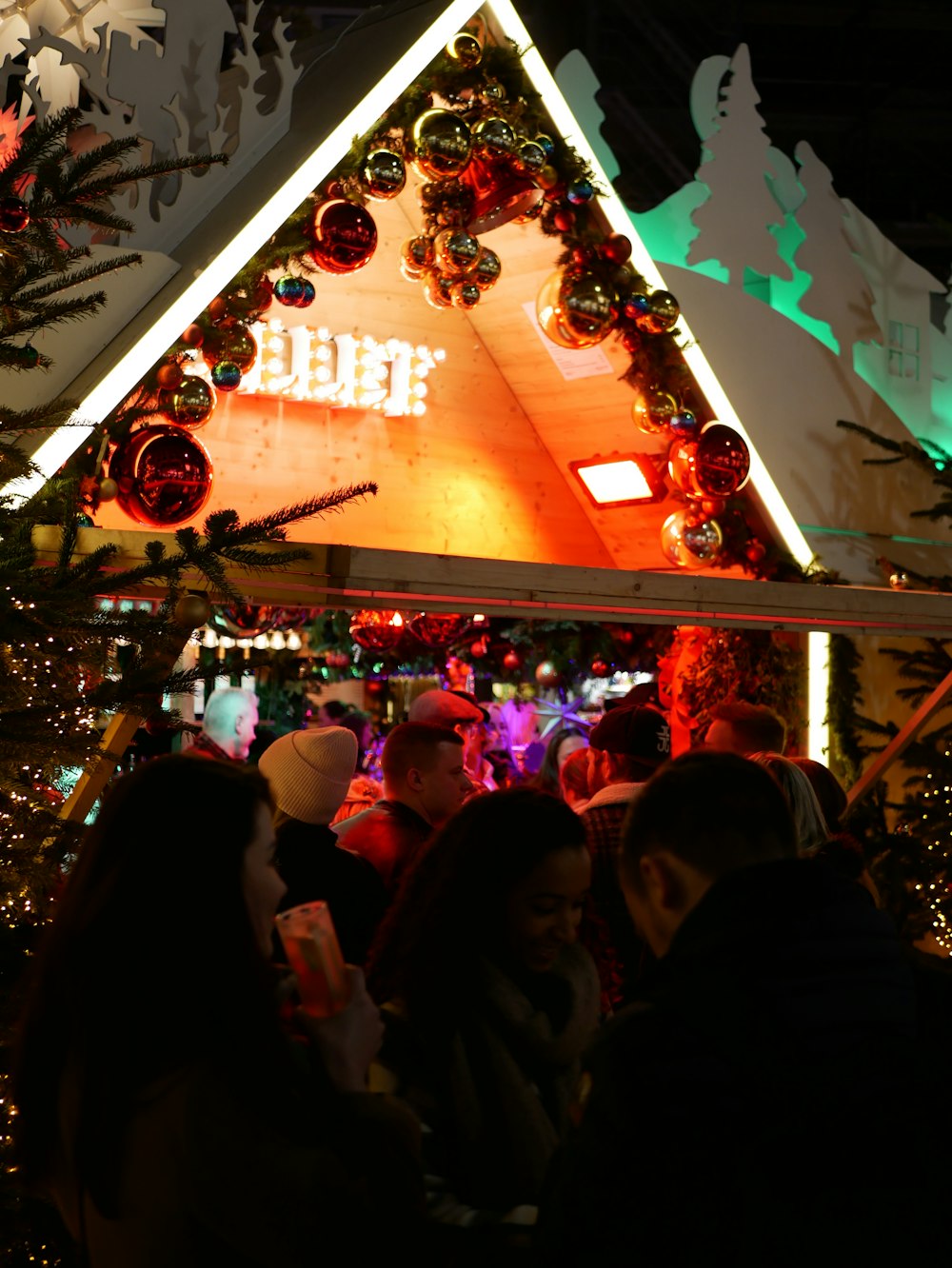 a group of people standing in front of a christmas display