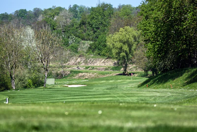 Kids lining up their drives on a wide fairway of a par 4 course under a sunny sky.