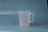 A translucent plastic measuring jug with a handle, placed against a plain blue background.