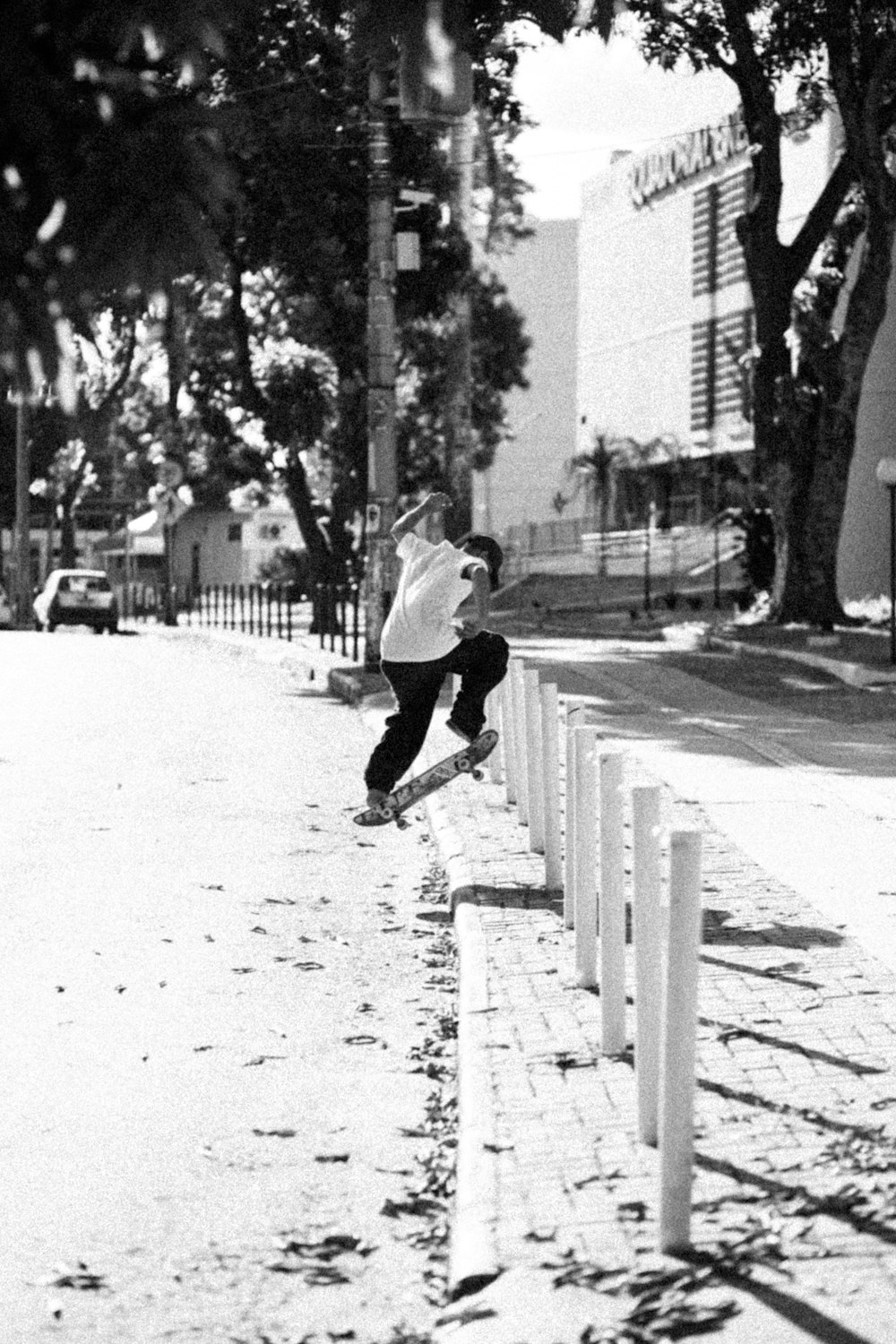 a man riding a skateboard down the side of a sidewalk