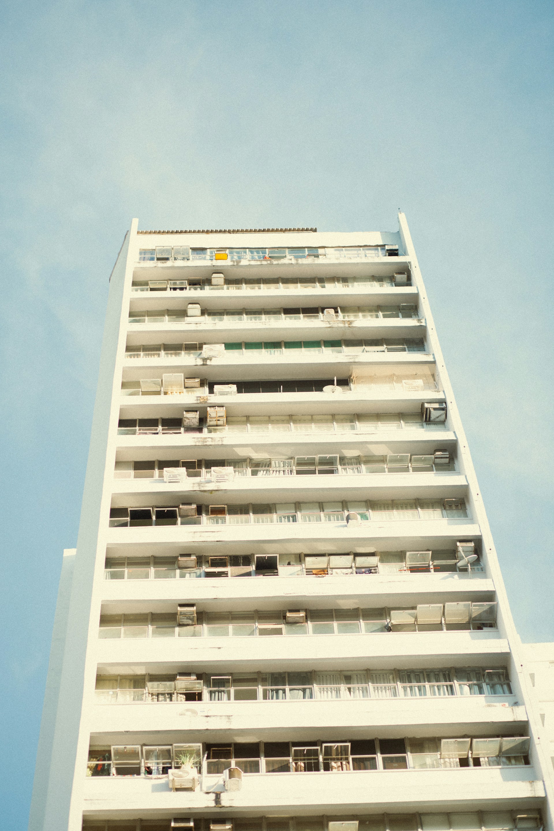 a tall white building with balconies and balconies