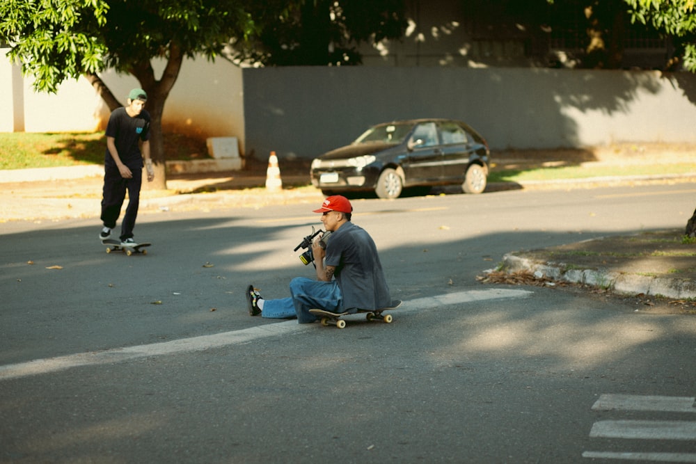 a man sitting on the ground on a skateboard