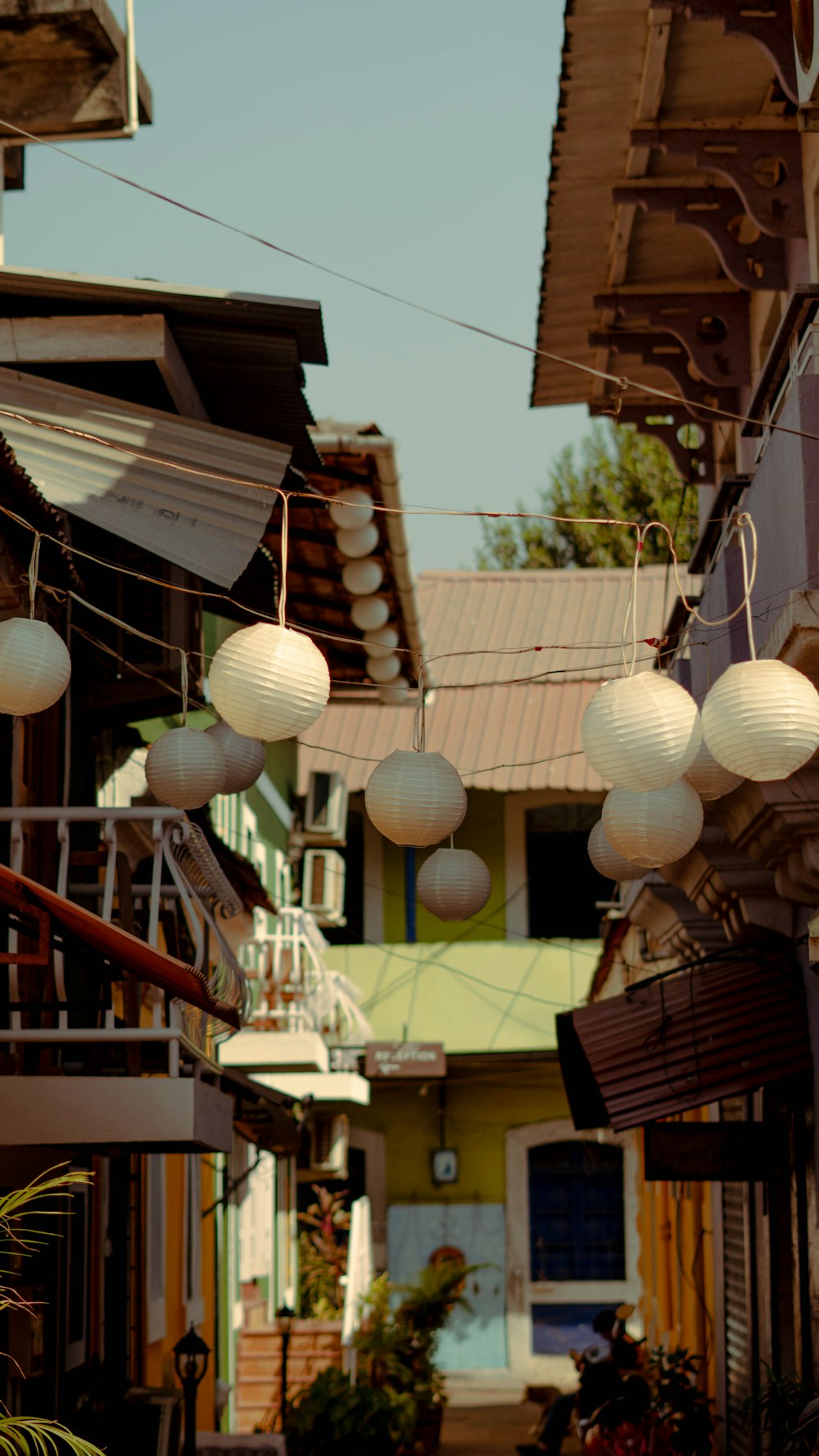 several white paper lanterns hanging from a line
