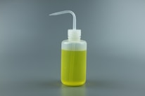 A clear plastic squeeze bottle filled with yellow liquid, featuring a bent spout for easy dispensing, against a plain gray background.