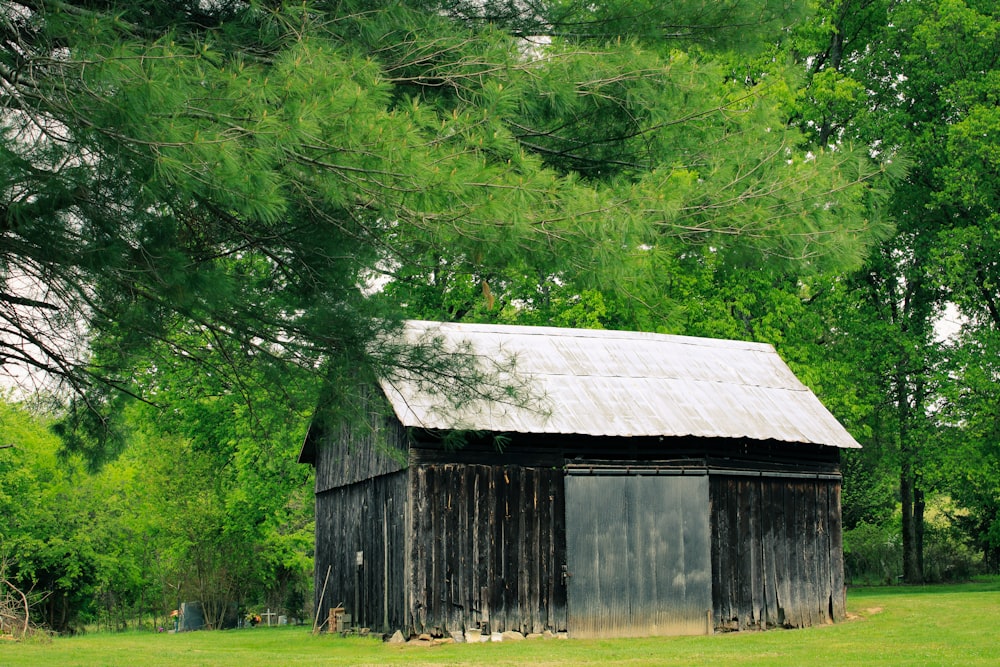 a barn in a field with trees in the background