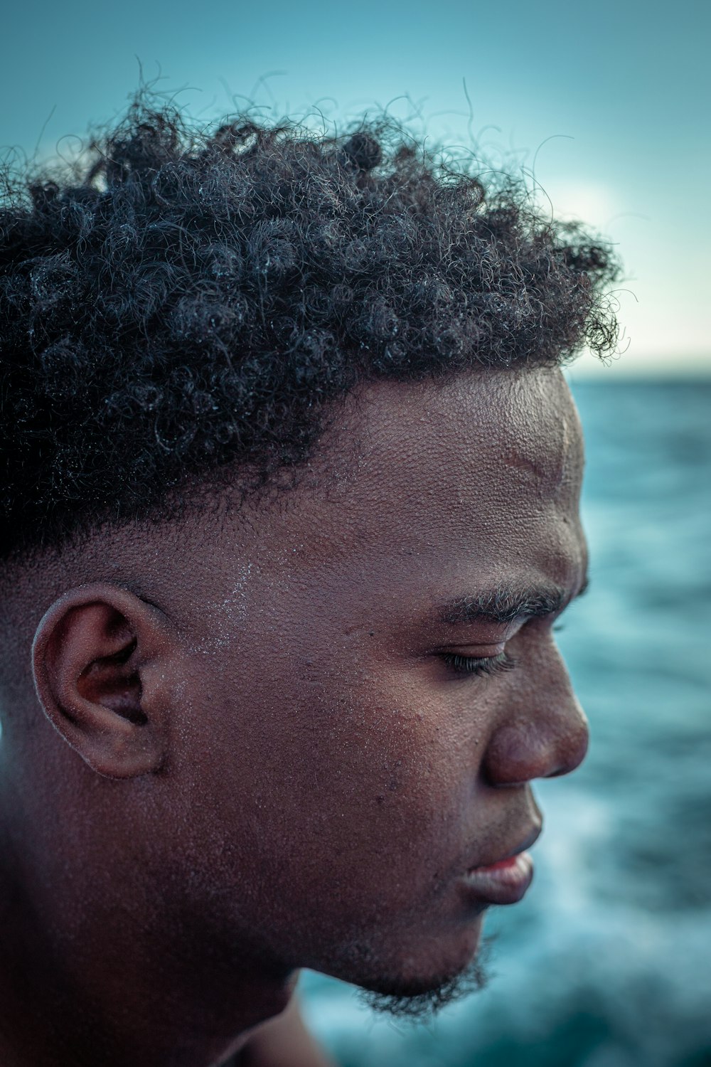 a close up of a person near the ocean