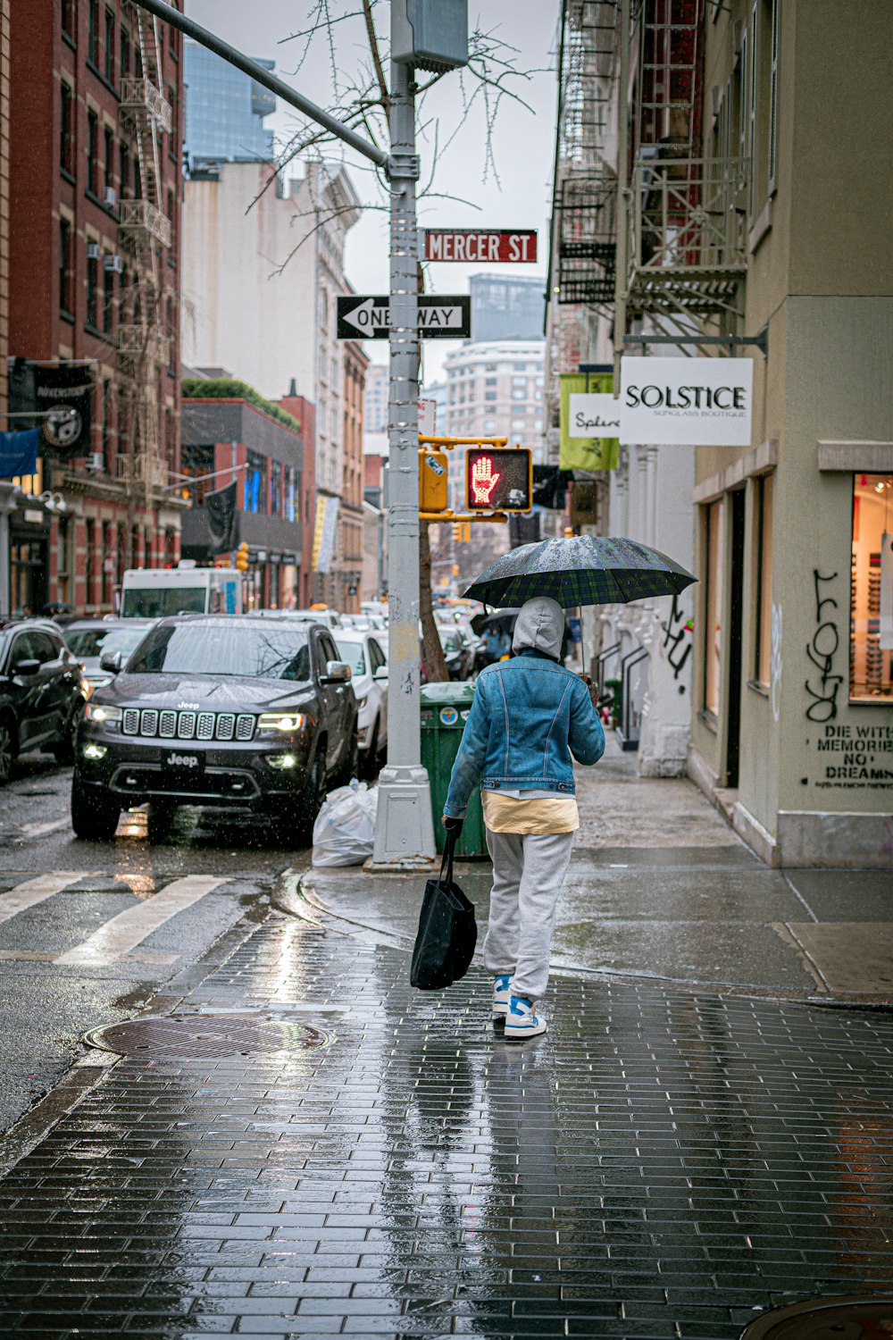 a person walking down a street holding an umbrella