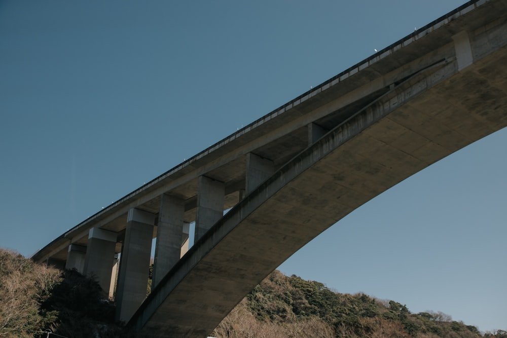 a bridge over a hill with a sky background