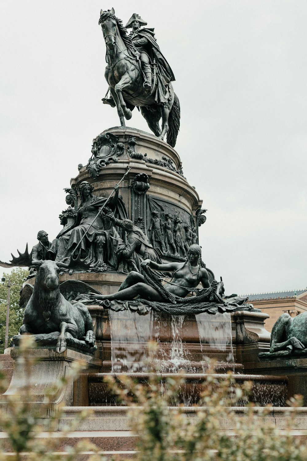 a statue of a man riding a horse on top of a fountain