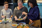 a group of people preparing food in a kitchen