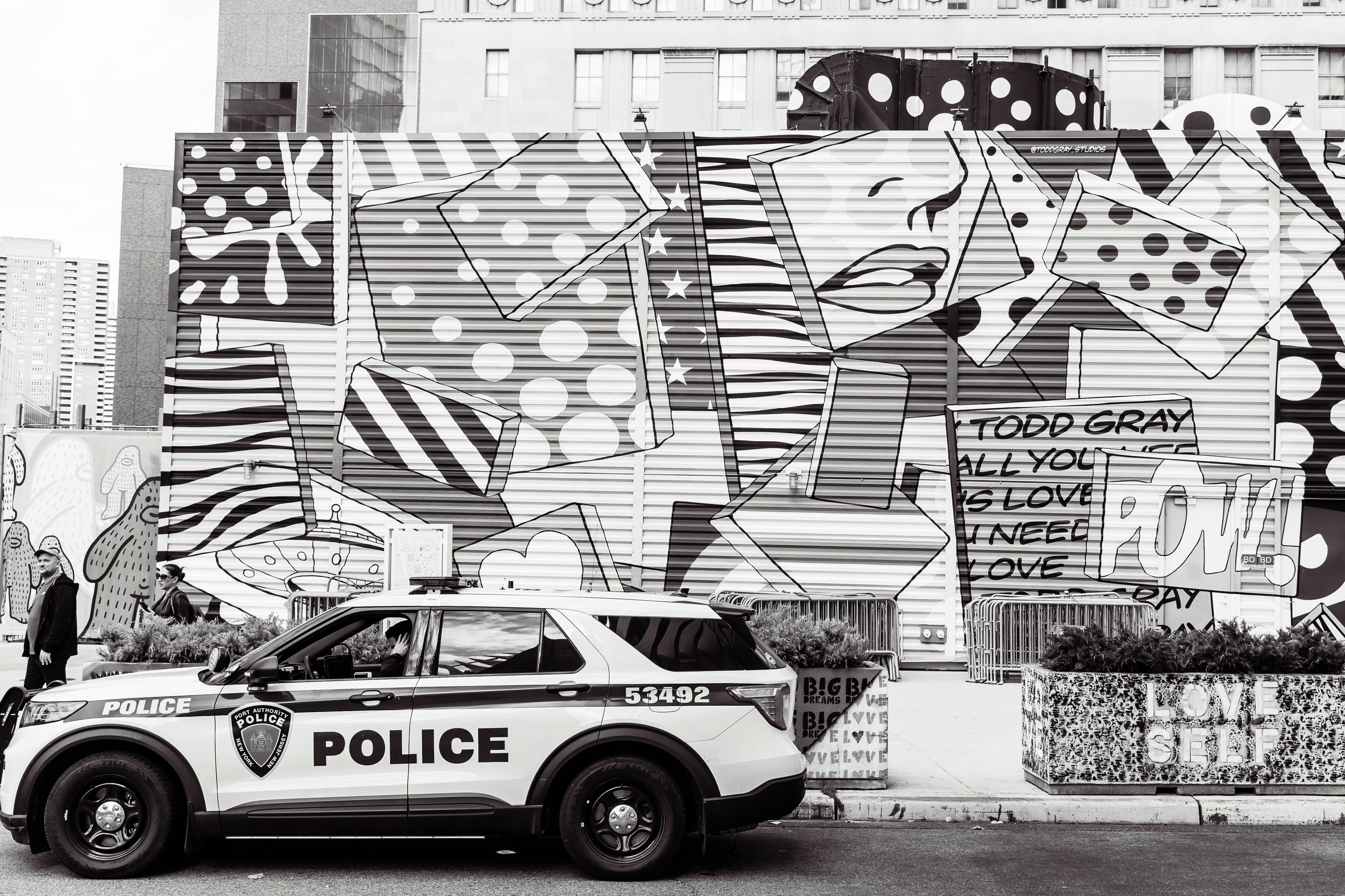 a police car parked in front of a wall covered in graffiti