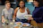 Residents sharing a meal together in a cozy kitchen, smiling and relaxed.