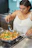 A man cooking a vibrant vegan stir-fry in a bright kitchen.