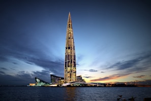 A sleek modern skyscraper in the UAE glowing under a twilight sky.