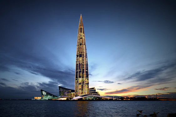 A sleek skyscraper with vertical lines glowing under a twilight sky, symbolizing strength and future growth.