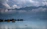 A serene view of Dal Lake with shikaras floating gently under a clear blue sky.