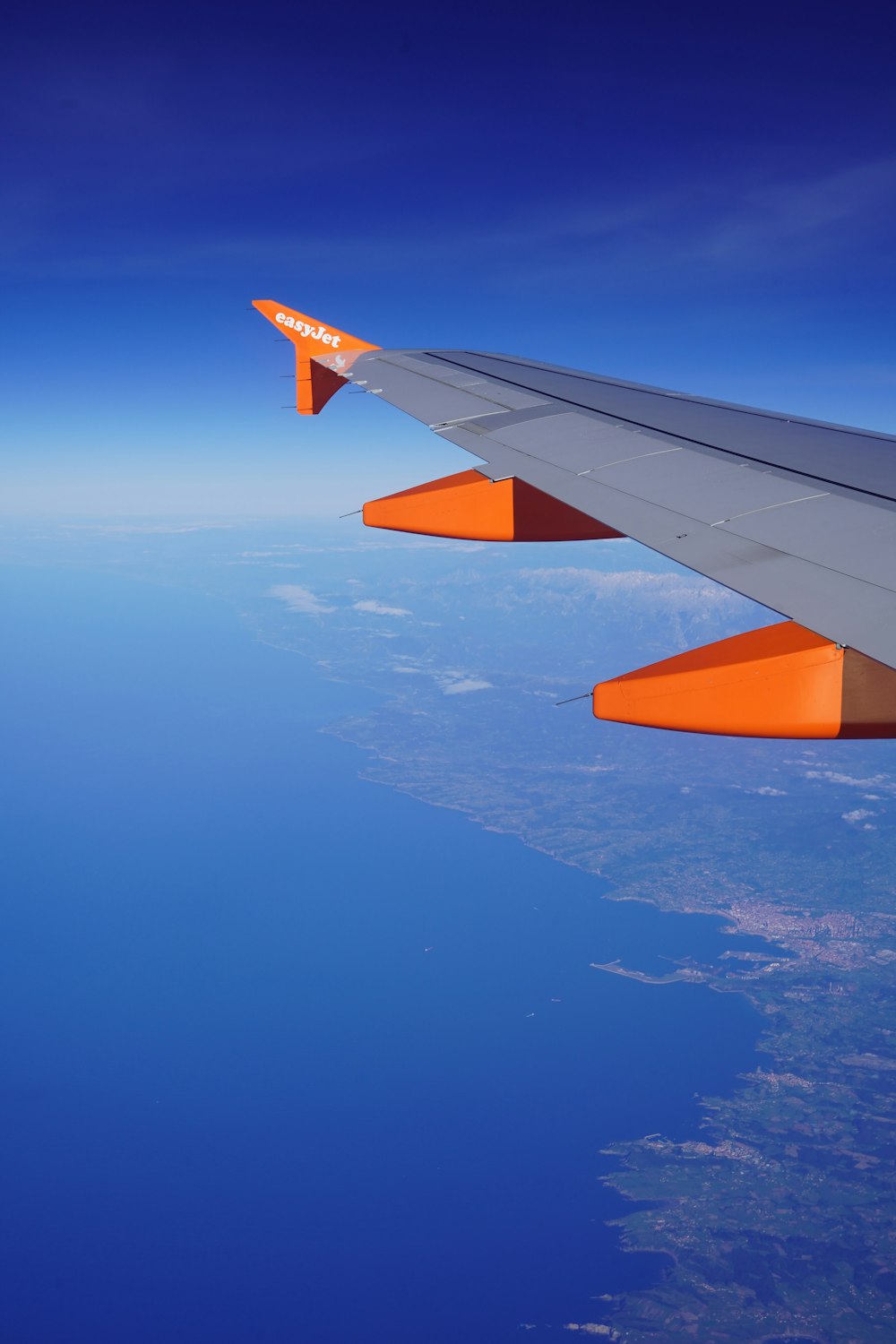 the wing of an airplane flying over the ocean