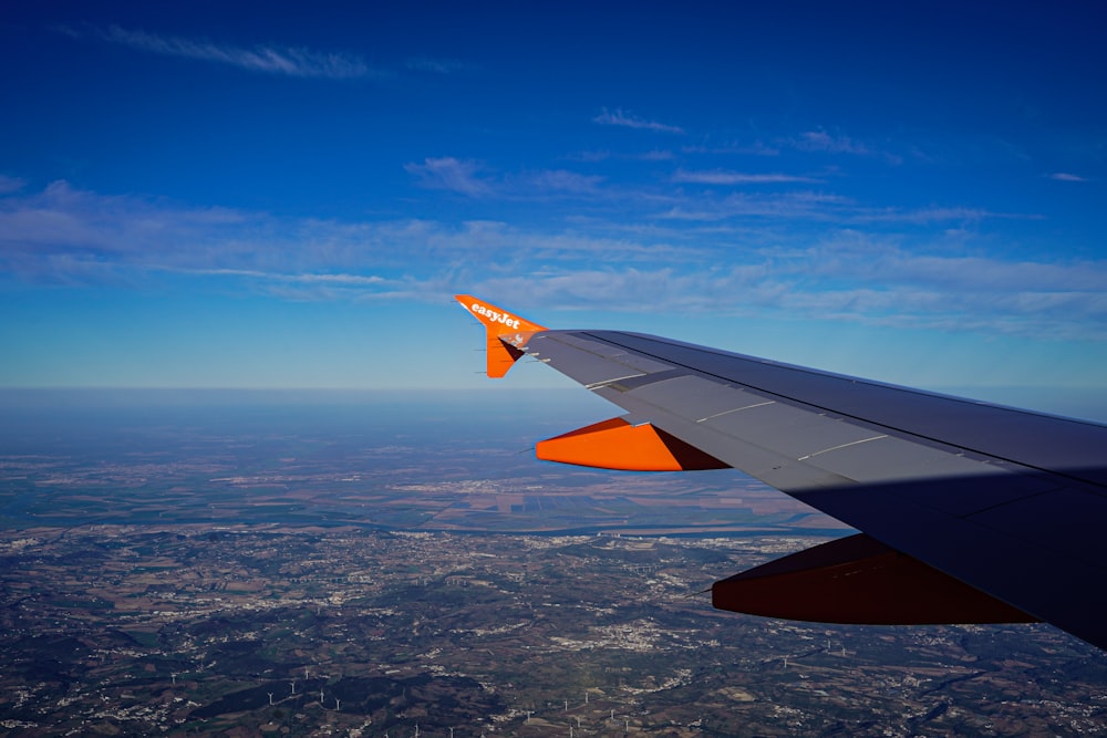 the wing of an airplane flying over a city