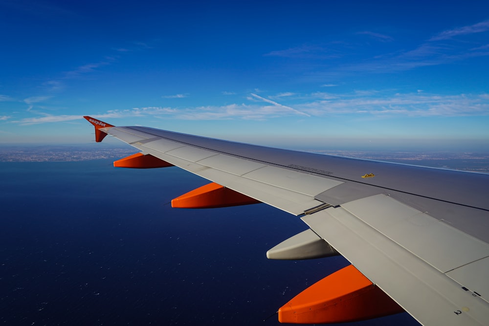 the wing of an airplane flying over the ocean