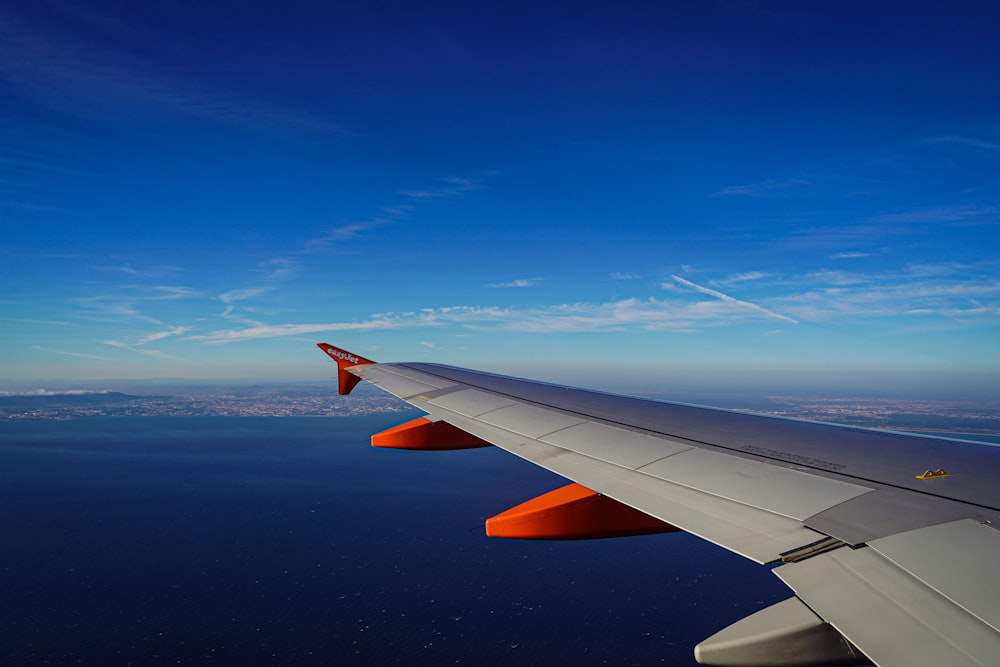 the wing of an airplane flying over the ocean