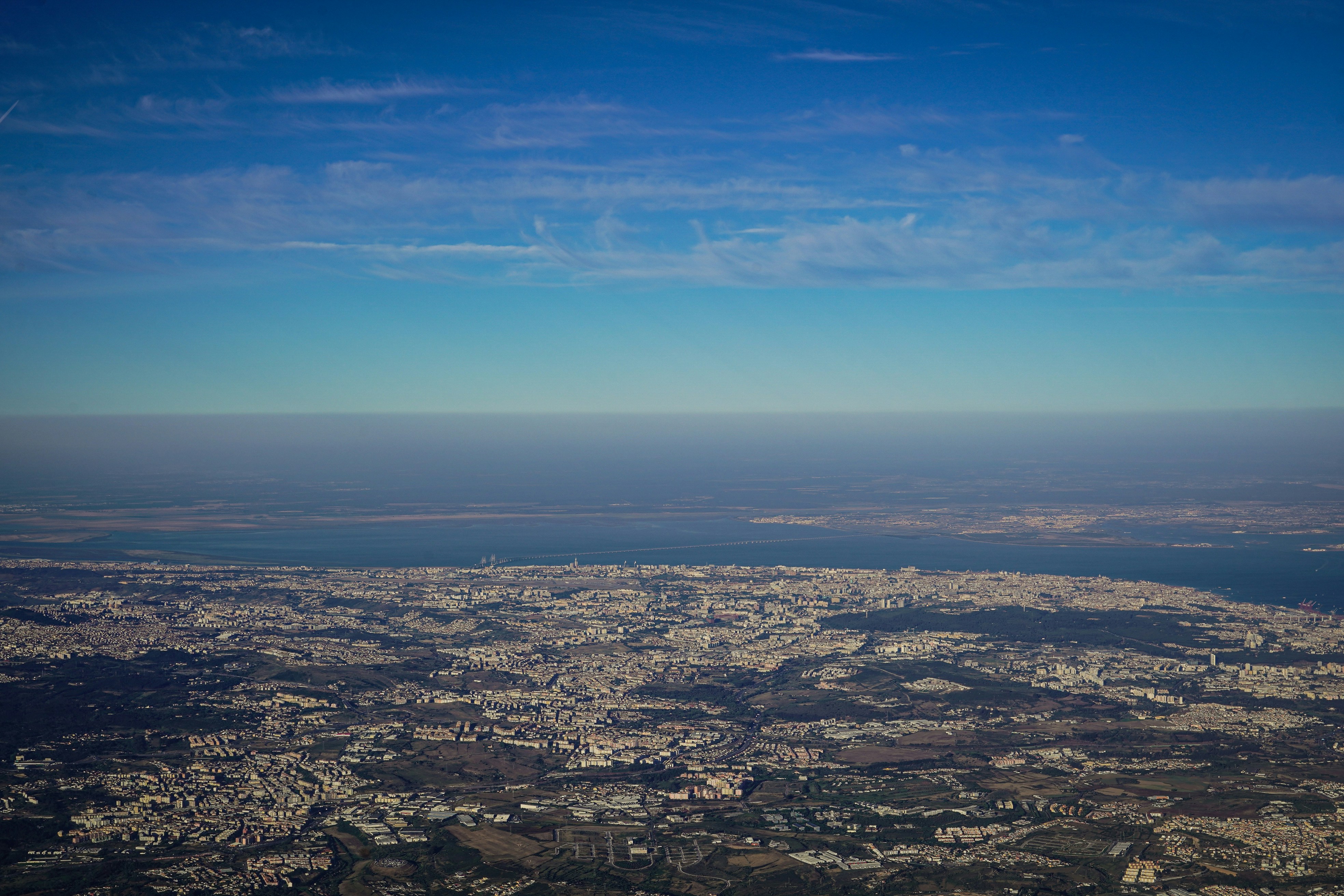 an aerial view of a city and a body of water, Photograph by Mark Stuckey.