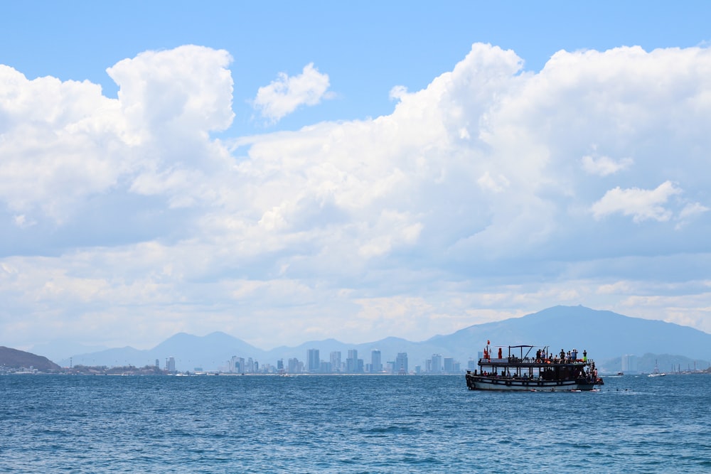 Un barco está en medio del océano con una ciudad al fondo