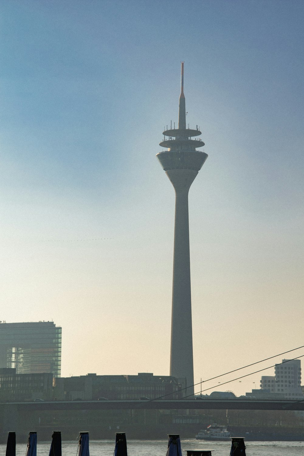 a tall tower towering over a city next to a body of water