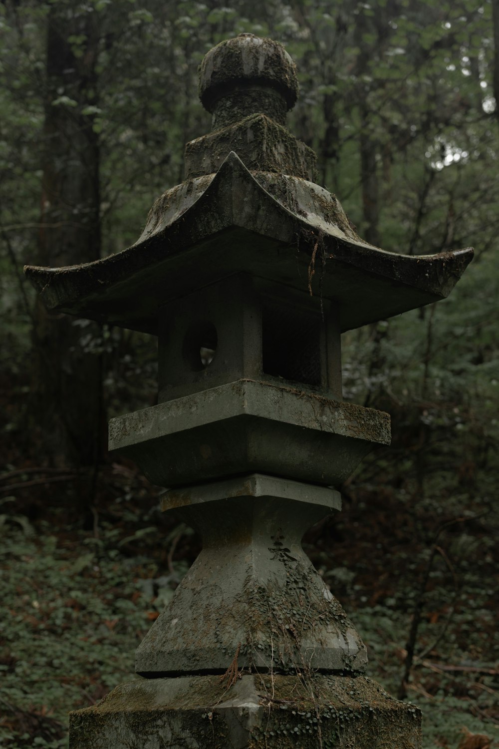 a stone lantern in the middle of a forest