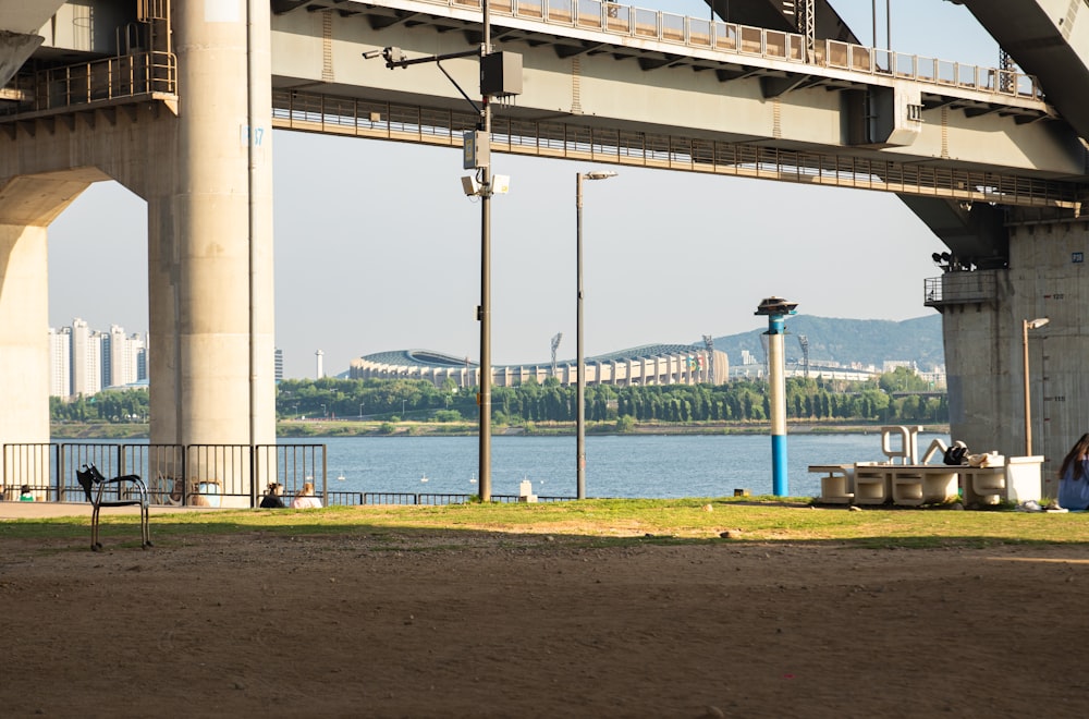 a person sitting on a bench under a bridge