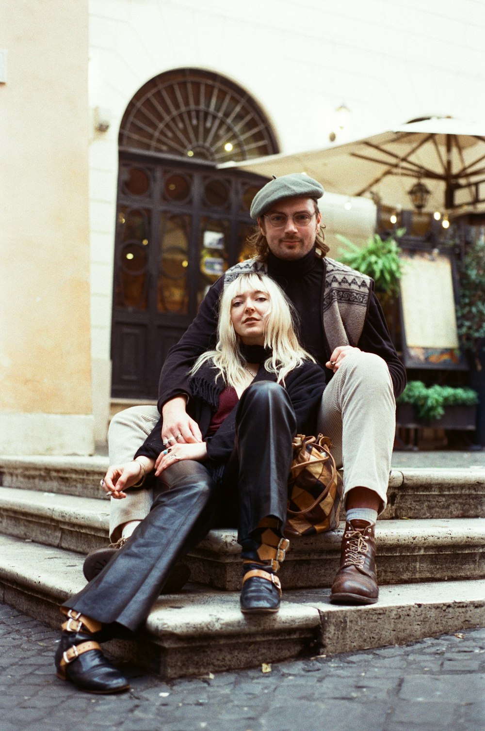 a man and a woman sitting on the steps of a building