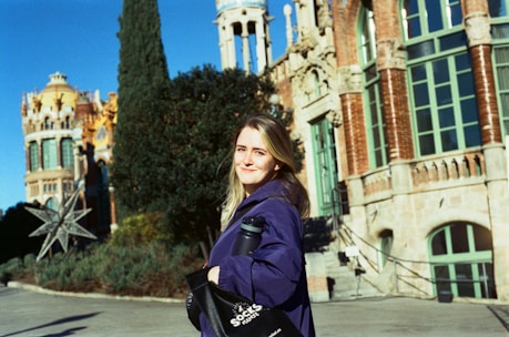 a woman is standing in front of a building