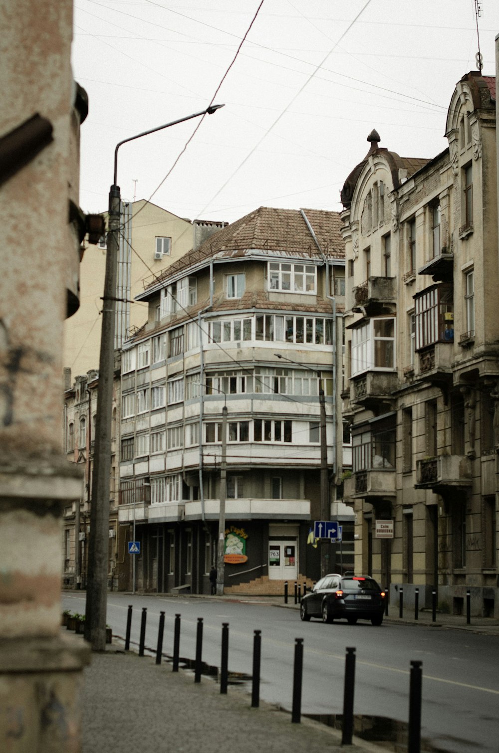 a car driving down a street next to tall buildings