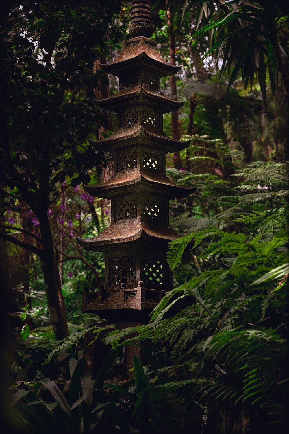 a tall pagoda in the middle of a forest