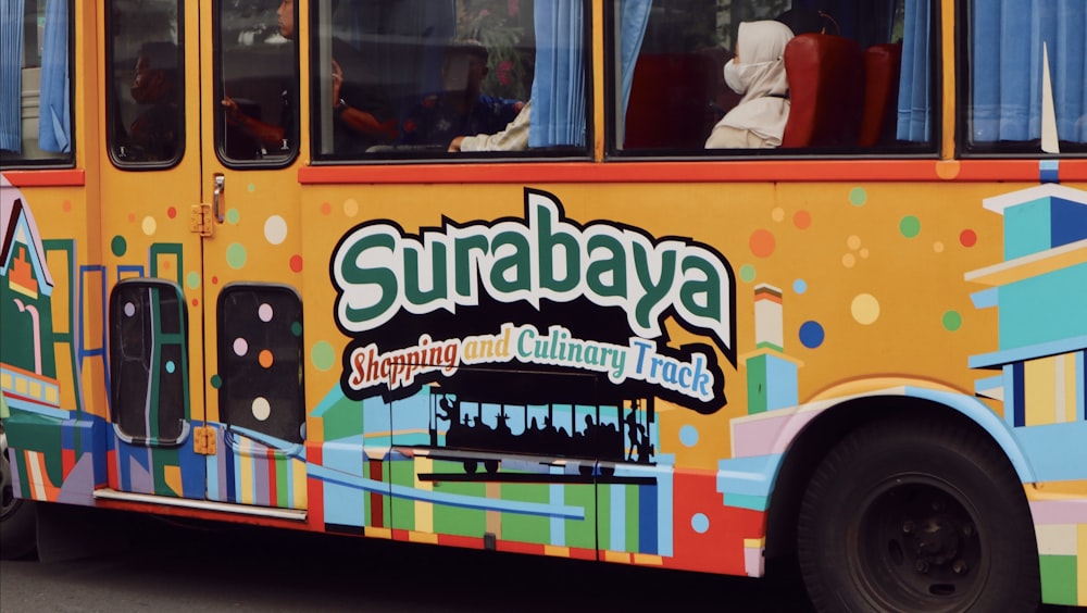 a brightly colored bus is driving down the street