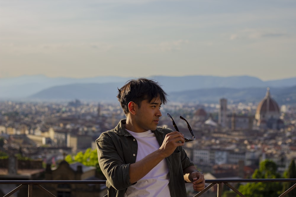 a man holding a pair of scissors in front of a city