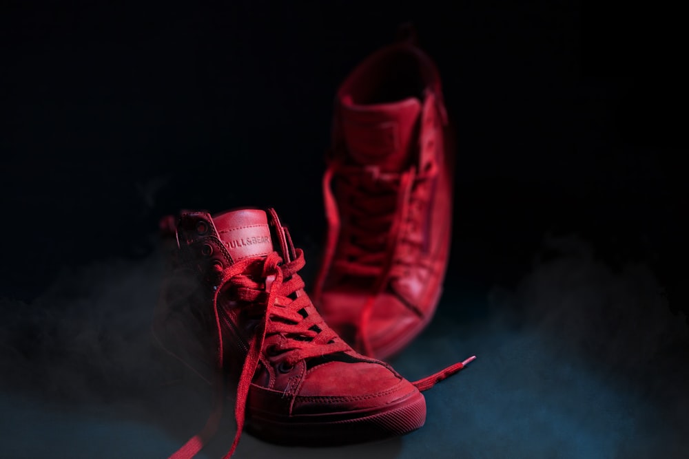 a pair of red sneakers sitting on top of a table