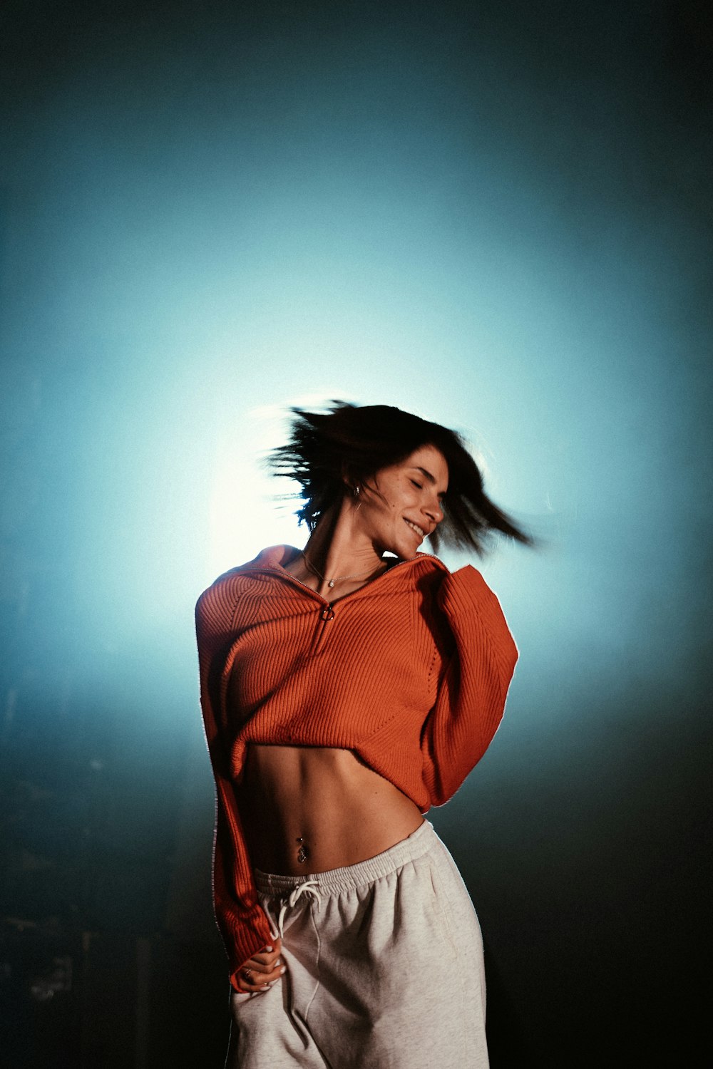 a woman in an orange top is dancing