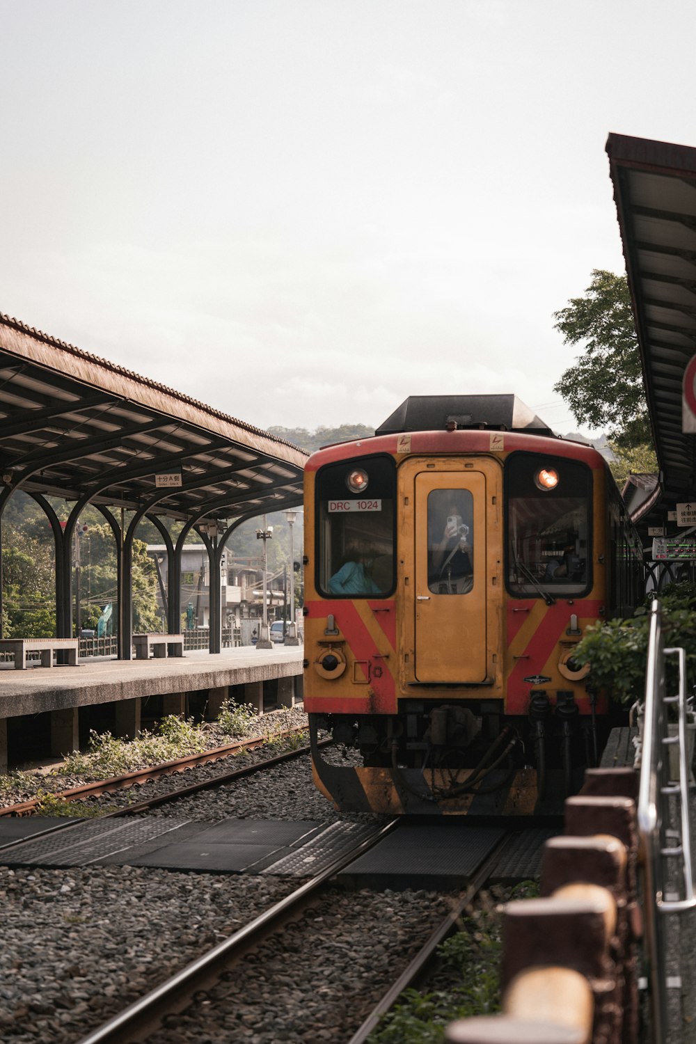 a yellow and red train pulling into a train station